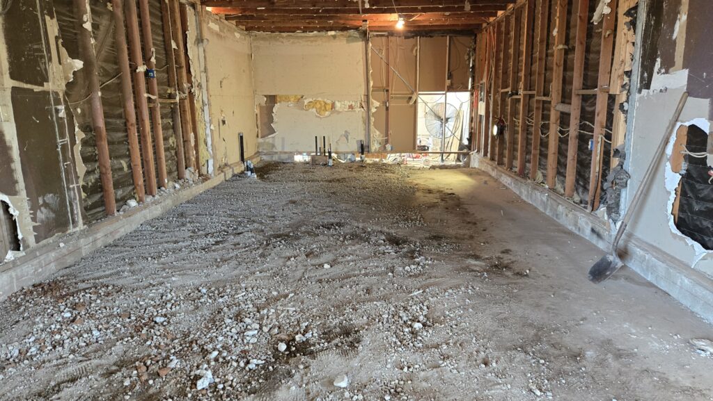 Interior demolition in Jamul CA with wall removal, debris pile, and exposed framing during remodel prep